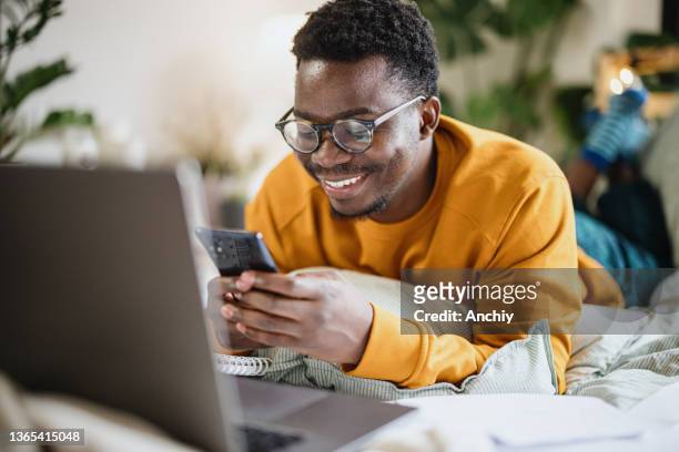 cheerful man using smart phone at home - 2021 planner stock pictures, royalty-free photos & images