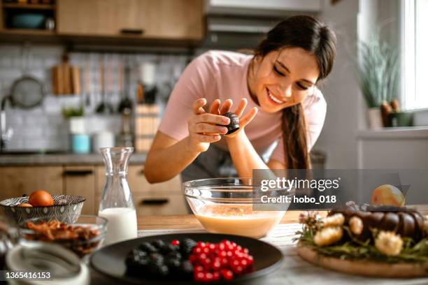 aggiunta di alcune spezie nella miscela di torte - kugelhopf foto e immagini stock