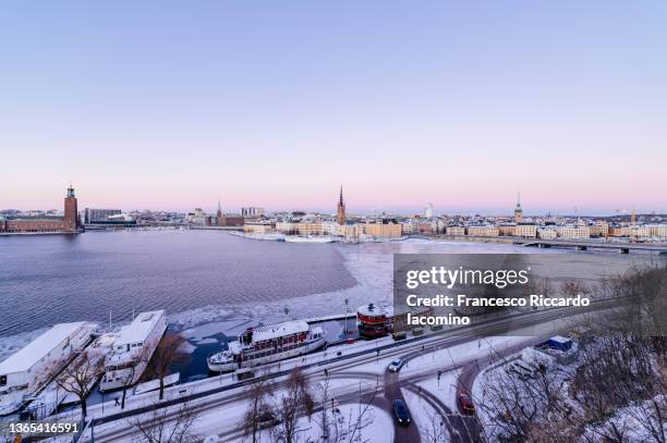 stockholm, scandinavia, sweden. city skyline at sunset in winter, with snow and frozen water - archipelago stockfoto's en -beelden