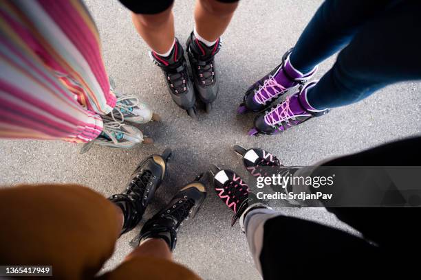 hochwinkelansicht einer gruppe von menschen, die rollschuhe tragen und im kreis stehen - skate sports footwear stock-fotos und bilder