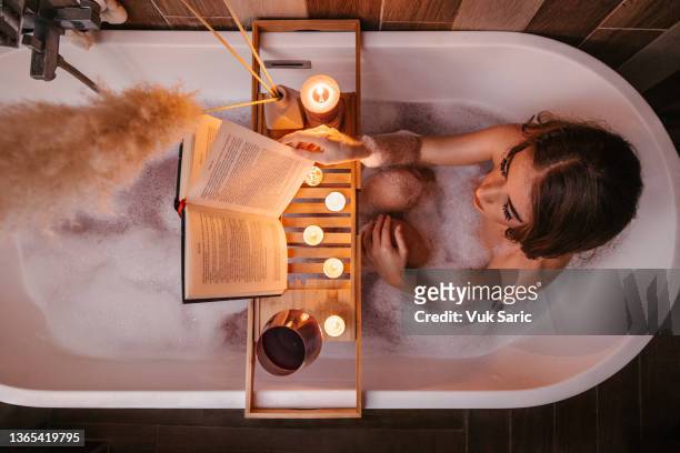 reading in a bathtub - domestic bathroom stock pictures, royalty-free photos & images