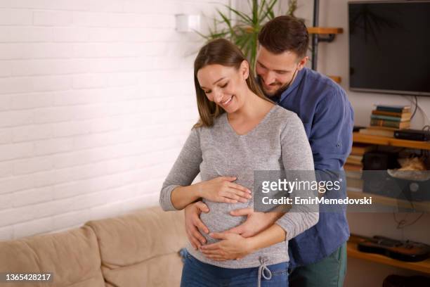 happy husband caresses the belly of his pregnant wife - new husband stock pictures, royalty-free photos & images