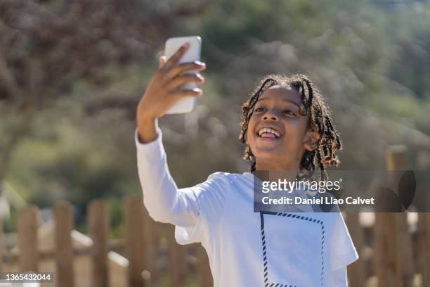 boy in a white t-shirt takes a selfie with his mobile phone - t mobile park stock pictures, royalty-free photos & images