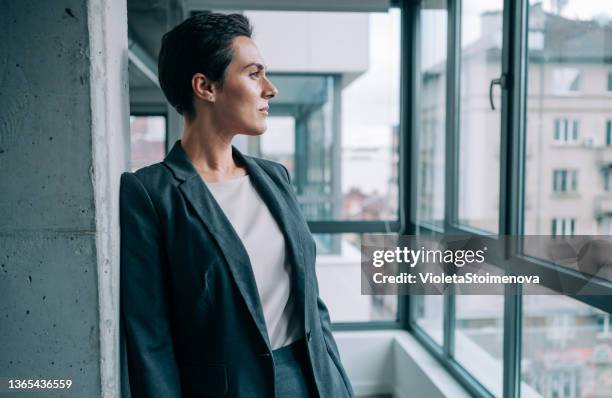 confident businesswoman in modern office. - olhar através da janela imagens e fotografias de stock