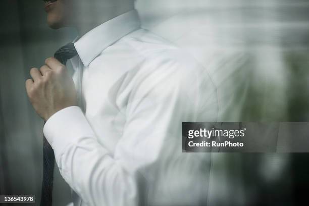 businessman in the office - adjusting necktie stockfoto's en -beelden