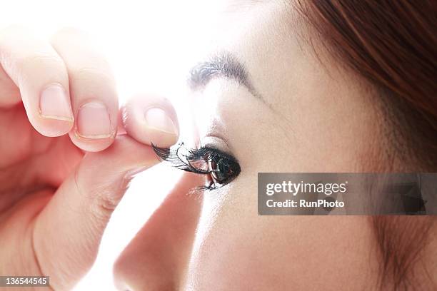 young woman removing false eyelash - false eyelash stock-fotos und bilder