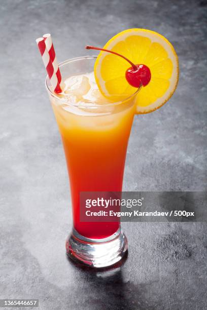 tequila sunrise cocktail,close-up of drink in glass on table - tequila sunrise stockfoto's en -beelden