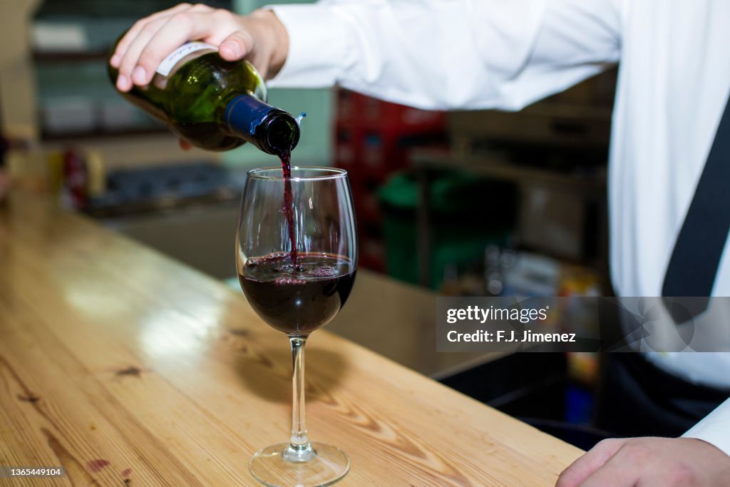 Close-up of waiter's hands pouring wine