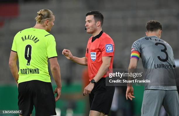 Erling Haaland Borussia Dortmund chats to referee Harm Osmers during the DFB Cup round of sixteen match between FC St Pauli and Borussia Dortmund at...