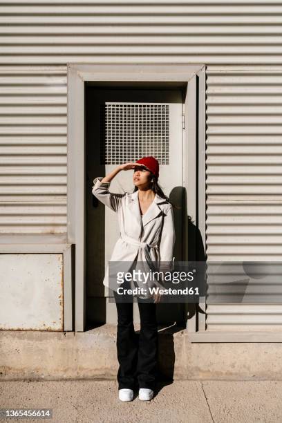 elegant woman shielding eyes on sunny day - signaling pathways stock-fotos und bilder