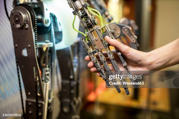engineer doing handshake with robotic arm at workshop - robot hand shake stock pictures, royalty-free photos & images