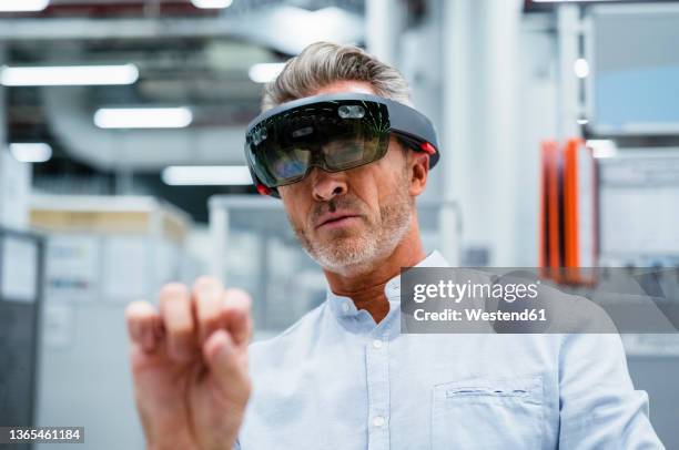 businessman using augmented reality eyeglasses at factory - ar stock pictures, royalty-free photos & images