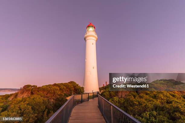 split point lighthouse standing against purple sky at dawn - boardwalk australia stock pictures, royalty-free photos & images