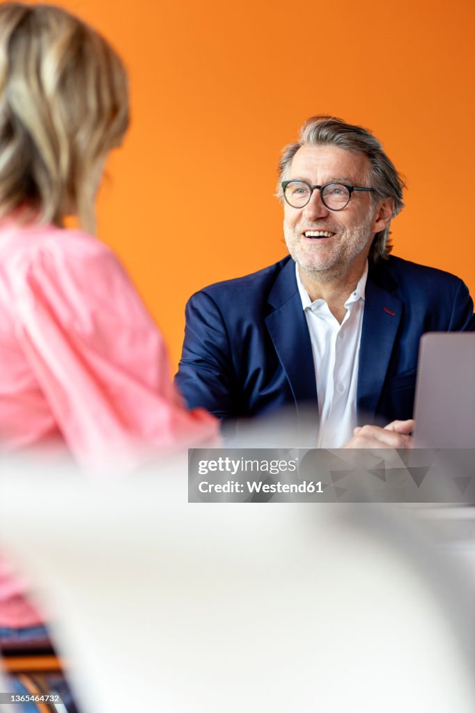 Businessman discussing with coworker at office