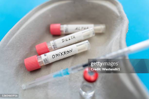 covid variant samples and injection with vaccine vial in kidney dish - booster dose stock pictures, royalty-free photos & images