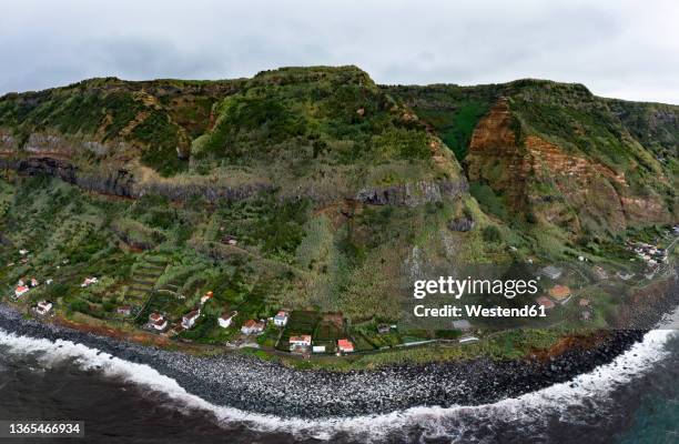 houses on coast with mountain range at rocha da relva, sao miguel island, azores, portugal - relva stock-fotos und bilder