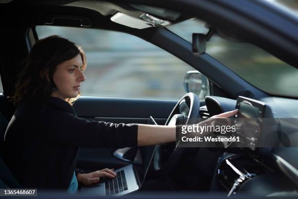 businesswoman with laptop using navigation device in driverless car - driverless cars fotografías e imágenes de stock