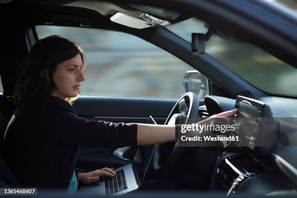 businesswoman with laptop using navigation device in driverless car - driverless car stock pictures, royalty-free photos & images