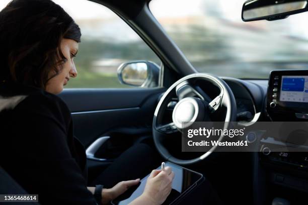 businesswoman using tablet pc in driverless car - self driving car stock pictures, royalty-free photos & images