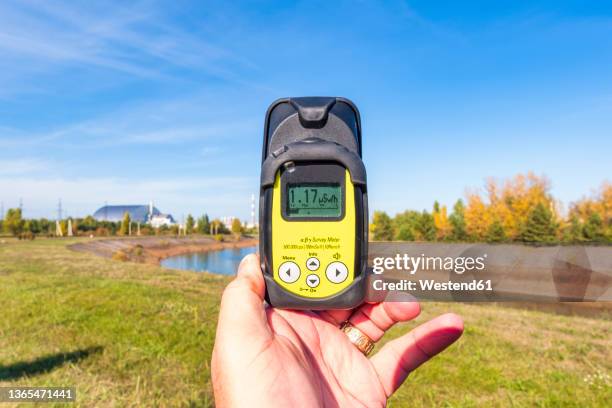 ukraine, kyiv oblast, chernobyl, hand of man using geiger counter to measure radiation levels nearchernobyl nuclear power plant - geiger fotografías e imágenes de stock