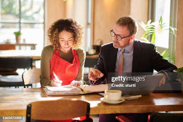 firmar el contrato de arrendamiento comercial - pequeña empresa fotografías e imágenes de stock