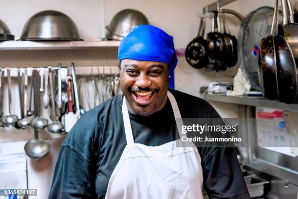 hispanic caribbean cook smiling looking at the camera at restaurant his kitchen - creole ethnicity stockfoto's en -beelden
