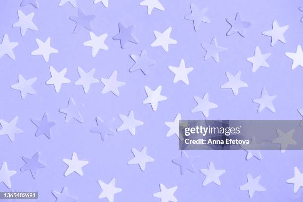 pastel violet festive background with many star shaped purple and white stickers. holidays celebration concept. photography from above. demonstrating very peri - color of 2022 year - star confetti white background stockfoto's en -beelden