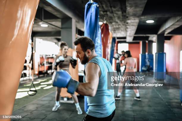 focused male athlete leading boxing gym to great results - boxing bag stock pictures, royalty-free photos & images