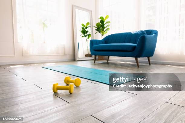 yoga mat,ball and weights  on floor at home gym - salle yoga photos et images de collection
