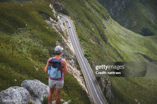 rückansicht der wanderfrau, die den blick über den bergpass genießt - car exterior rear high angle stock-fotos und bilder