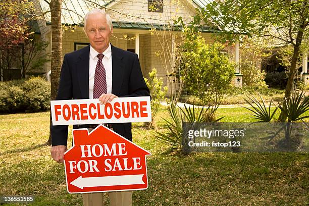 real estate agent holds foreclosure real estate sign. home for sale. - estate agent sign stockfoto's en -beelden