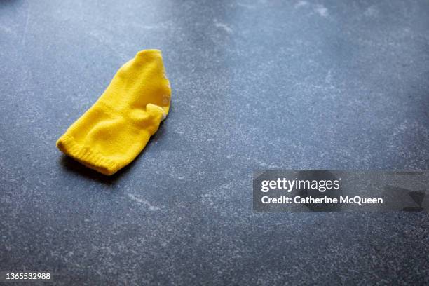 single yellow sock left on laundry room counter - lost sock stock pictures, royalty-free photos & images