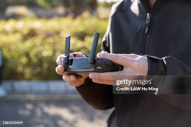 a pair of hands holding a drone's remote control - radio controlled handset stock pictures, royalty-free photos & images