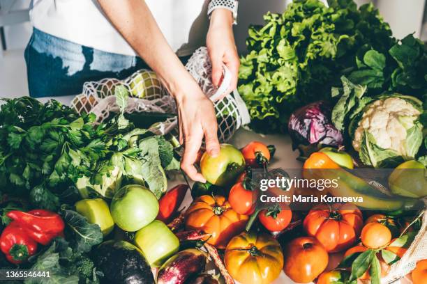 woman takes fresh organic vegetables - débarrasser la table photos et images de collection