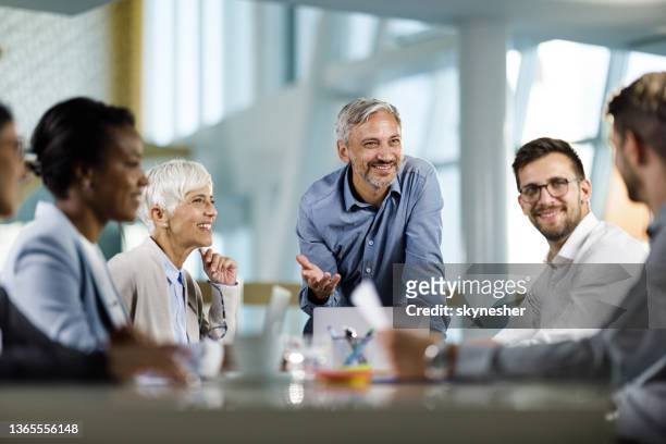 feliz ceo masculino hablando con su equipo en una reunión en la oficina. - ceo fotografías e imágenes de stock