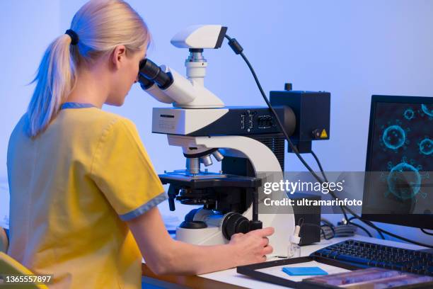 women doctor in medical laboratory developing new vaccines coronavirus covid-19. medical test at the lab. scientist in laboratory working with medical samples using modern electron microscope. medical research devices for analyzes virus microbiology - elektronenmicroscopisch-beeld stockfoto's en -beelden