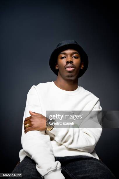 handsome young man wearing white sweatshirt - black hat stockfoto's en -beelden