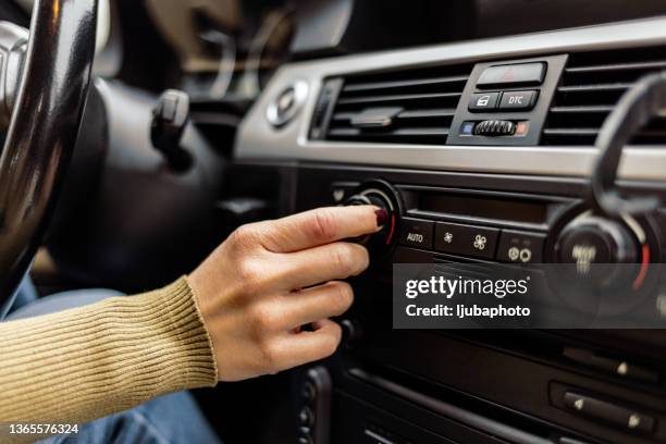 woman adjusting the cooling inside her car - boom for real stock pictures, royalty-free photos & images