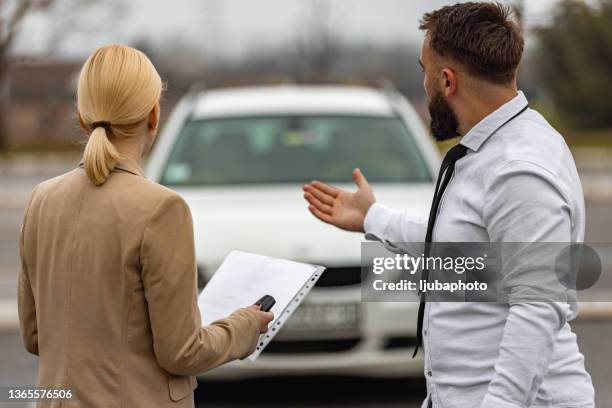 couple on road trip standing by the car - tweedehands autoverkoop stockfoto's en -beelden