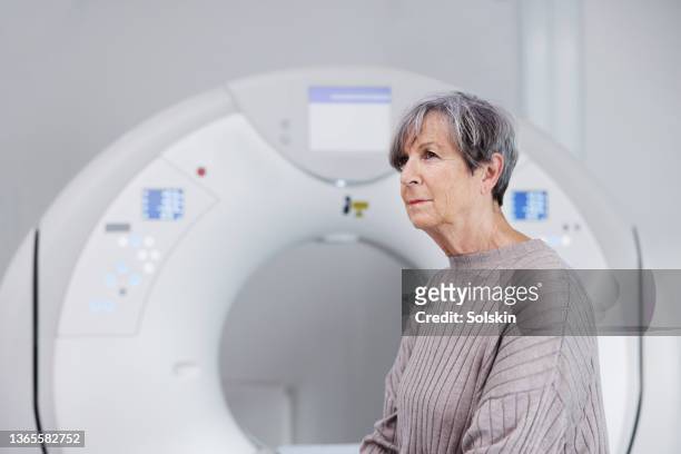 patient getting ready, sitting on medical cat scanner - scientific imaging technique stock pictures, royalty-free photos & images