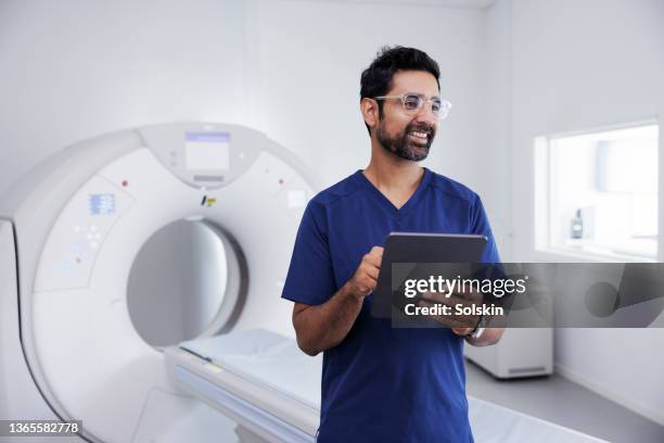 doctor standing by medical scanner - medical equipment hospital stock pictures, royalty-free photos & images