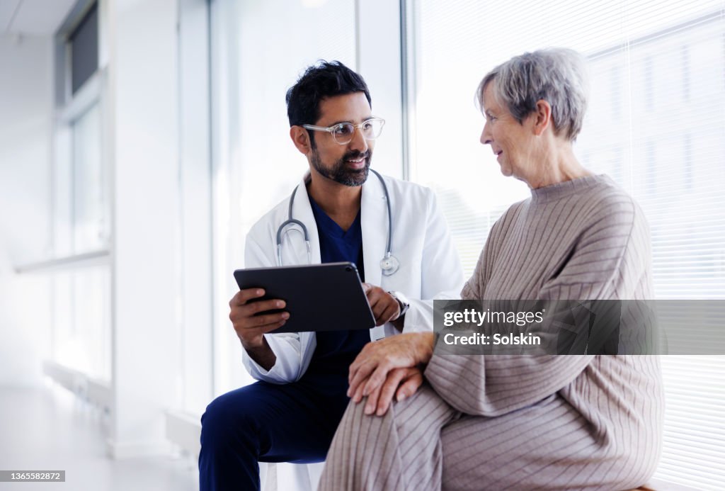 Doctor and patient in conversation, looking at digital tablet