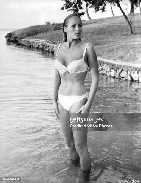 Ursula Andress standing in the water wearing a bikini in a scene from the film 'James Bond: Dr. No', 1962.