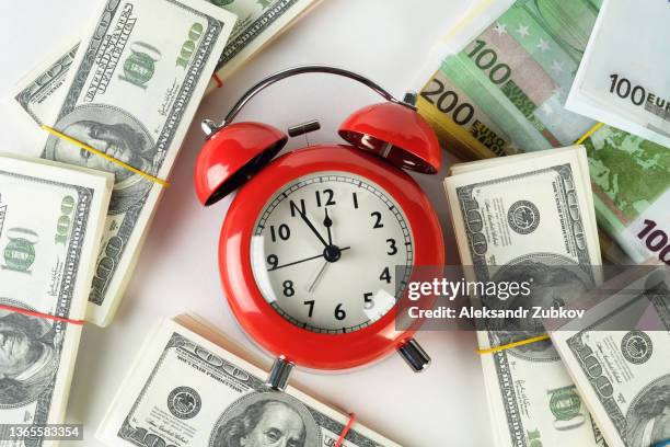 a retro-style alarm clock on a stack of paper dollars and euros. time is money. business concept. paper currency, dollar bills in bundles on a white background or table. the concept of business and finance, insurance, investment and accumulation of funds. - tax reform stockfoto's en -beelden