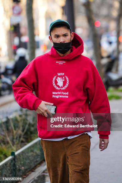 Guest wears a green cap with beige embroidered 'Cafe de Flore' slogan, a red with white embroidered slogan and logo sweater from World Food...