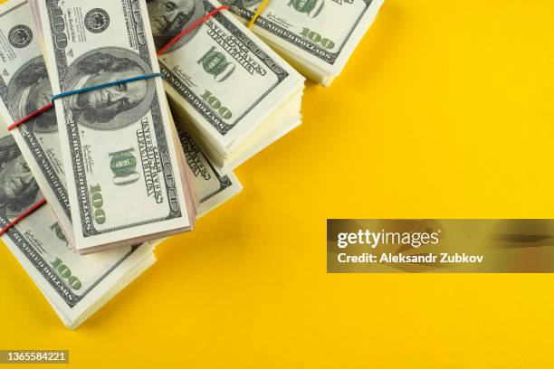 a banknote in us dollars in bundles on a bright background. the concept of finance and economics, investments. salary, bribe, profit or credit funds. space for copying. - cash bribe ストックフォトと画像