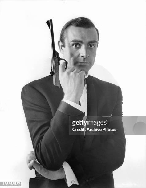 Sean Connery pointing a gun up with his finger on the trigger in a scene from the film 'James Bond: From Russia With Love', 1963.