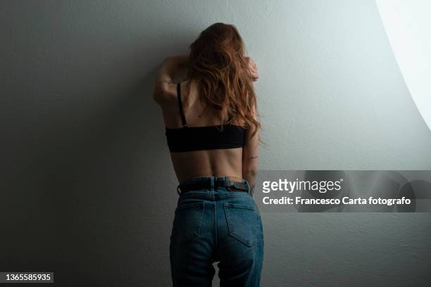 sad woman leaning on wall - name tattoos stock pictures, royalty-free photos & images