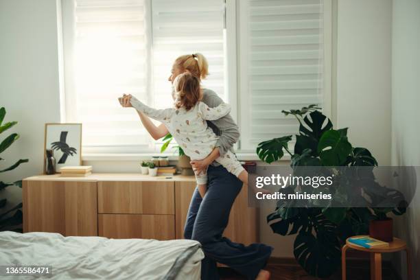 fröhliche frau tanzt morgens mit ihrer tochter - baby dancing stock-fotos und bilder