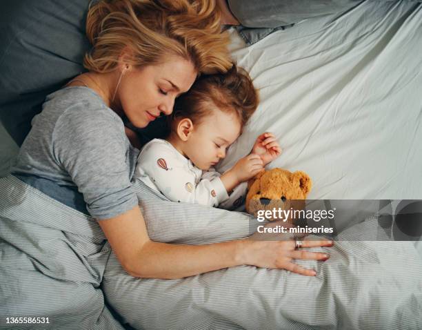 draufsichtsaufnahme von mutter und kind, die morgens bequem auf der seite schlafen - stofftier stock-fotos und bilder